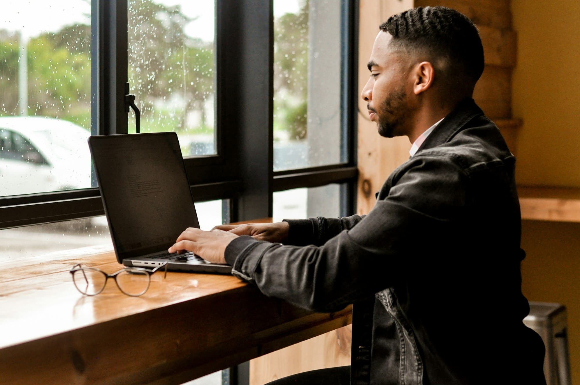 A man going through figures on a laptop by a window