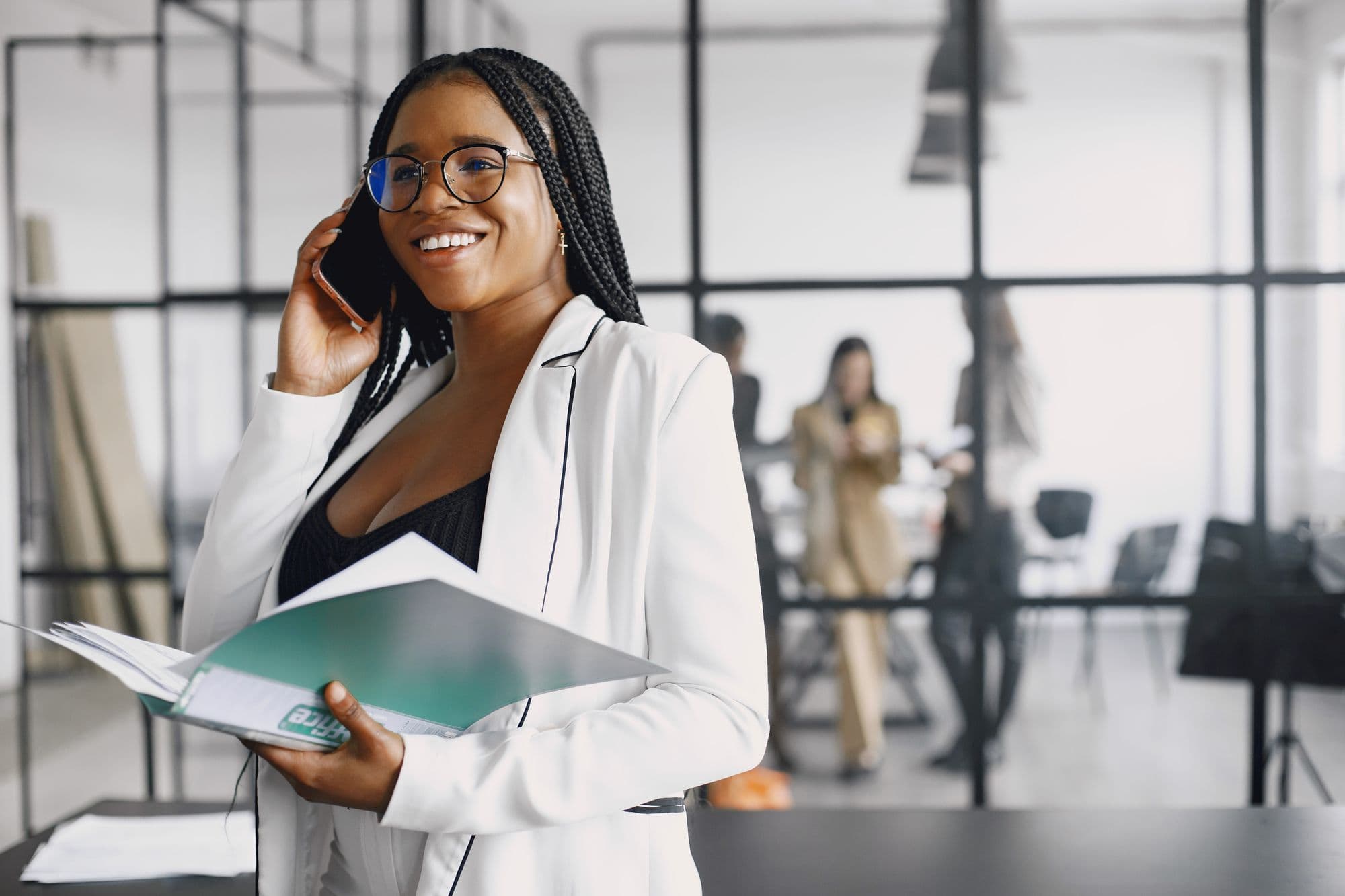 A businesswoman on a call, documents in hand